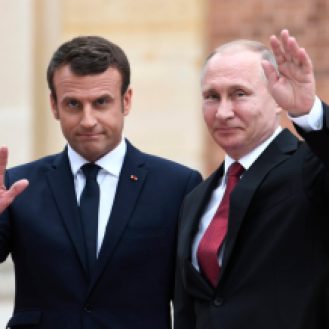 Russian President Vladimir Putin (R) and French President Emmanuel Macron (L) wave upon their arrival at the Versailles Palace, near Paris, on May 29, 2017, ahead of their meeting. French President Emmanuel Macron hosts Russian counterpart Vladimir Putin in their first meeting since he came to office with differences on Ukraine and Syria clearly visible. / AFP PHOTO / STEPHANE DE SAKUTIN (Photo credit should read STEPHANE DE SAKUTIN/AFP/Getty Images)